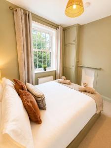 a bedroom with a large white bed with pillows on it at St Johns Central Canterbury Cottage in Canterbury +30 photos
