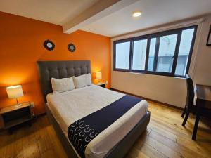 a bedroom with a large bed and a window at Singular Sócrates in Mexico City