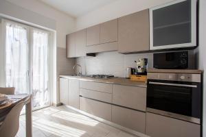 a kitchen with white cabinets and a stove top oven at Kama House 96 mq in centro in Lesina