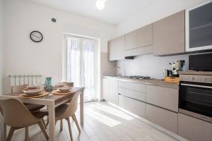 a kitchen with a table and chairs and a kitchen with white cabinets at Kama House 96 mq in centro in Lesina