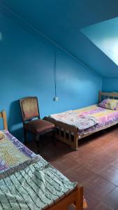a blue room with two beds and a chair at Ararat in Ozurgetʼi