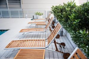 three wooden benches sitting on a deck with plants at Top Rentals Downtown in Buenos Aires