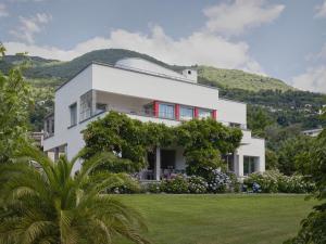 a white house with a hill in the background at Casa Navegna in Minusio