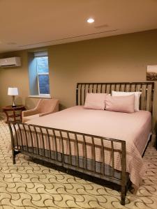 a bedroom with a large bed with pink pillows at Mill Creek Gardens in Winamac