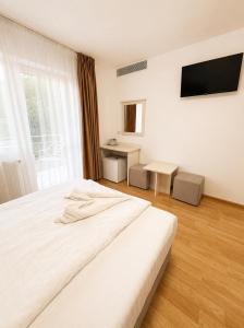 a bedroom with a large white bed and a window at Balea Events in Cîmpeni