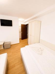 a white room with a bed and a tv at Balea Events in Cîmpeni