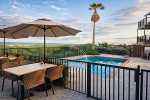 a patio with tables and an umbrella and a swimming pool at Palms Resort & Cafe on the Beach in South Padre Island