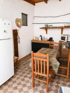 a kitchen with a table and a white refrigerator at Alojamiento EYO en Chuy con Baño Privado y Aire Acondicionado in Chuy