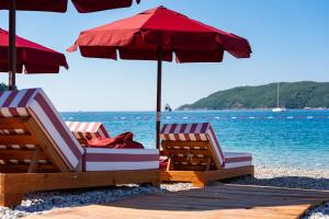 two chairs and an umbrella on a beach at Hotel Imperial Conference & Spa in Budva