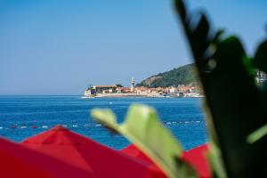 a view of the ocean with red umbrellas at Hotel Imperial Conference & Spa in Budva