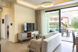a living room with a white couch and a tv at TATOLI Villas in Minia