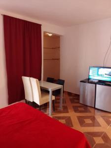 a room with a table and chairs and a television at Bchome hostal in Boca Chica