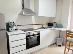 a white kitchen with a stove and a sink at Estudio en Villalonga in Pontevedra