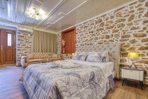 a bedroom with a large bed and a stone wall at Pietra Grand Suite in Nafplio