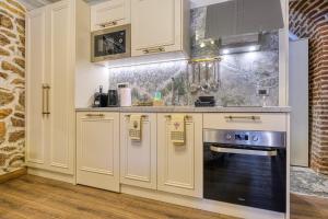 a kitchen with white cabinets and a stove at Pietra Grand Suite in Nafplio