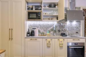 a kitchen with white cabinets and a counter top at Pietra Grand Suite in Nafplio +9 photos