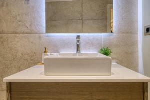 a white sink in a bathroom with a mirror at Pietra Grand Suite in Nafplio