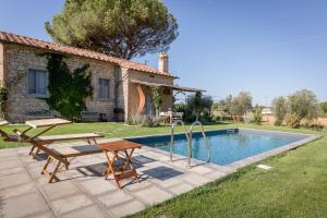 una piscina con mesa y sillas junto a una casa en Villa Il Nido, en Cortona