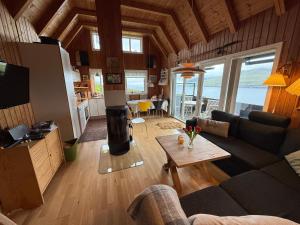 a living room with a couch and a coffee table at Unique and isolated cottage with stunning views in Leynar