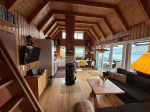 a living room with a couch and a table at Unique and isolated cottage with stunning views in Leynar
