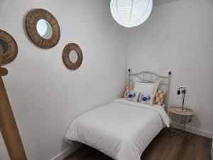 a bedroom with a bed and two mirrors on the wall at Casa A Beira do Mar in O Grove