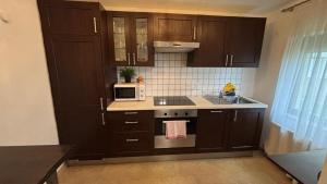 a kitchen with dark brown cabinets and a microwave at Alina in Graz +1 photo