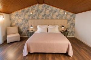 a bedroom with a large bed and a chair at Quinta da Terrincha in Torre de Moncorvo +45 photos