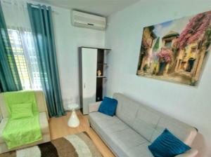 a living room with a gray couch and blue pillows at Eco Bay Montenegro in Donji Morinj +12 photos
