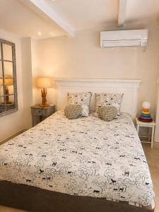 a bedroom with a bed with a white comforter at Le Tiki Lodge in Fréjus