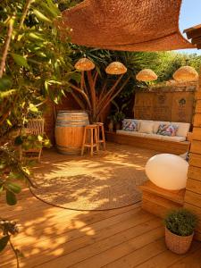 a patio with a bench and a table and a tree at Le Tiki Lodge in Fréjus