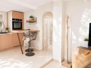 a kitchen with a table and a chair in a room at Le Tiki Lodge in Fréjus