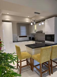 a kitchen with white cabinets and a table and chairs at Zill Hawana in Ma‘mūrah