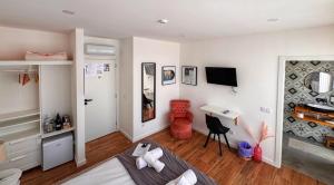 a room with a bed and a desk and a television at Pata da Gaivota Boutique House in Lourinhã