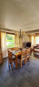 a dining room with a wooden table and a chandelier at Matices Patagonicos in San Carlos de Bariloche