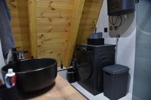 a bathroom with a black stove and a trash can at Magic Forest Durmitor in Motički Gaj +33 photos