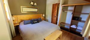 a bedroom with a white bed with blue pillows at Matices Patagonicos in San Carlos de Bariloche
