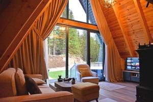 a living room with a large window in a cabin at Magic Forest Durmitor in Motički Gaj