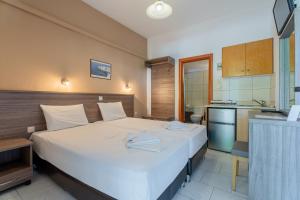 a hotel room with a bed and a kitchen at Studios Vaso in Neos Marmaras