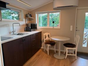 a kitchen with a sink and a table with chairs at Stuga Marstrand in Marstrand
