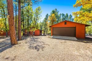 an orange building with a garage next to trees at Wild West Wonder in Pinetop-Lakeside