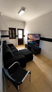 a living room with a couch and a flat screen tv at Albani Hostel in Palmela