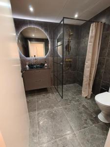 a bathroom with a sink and a toilet and a mirror at Sea view Ella - Hejlsminde Badehotel in Hejlsminde +4 photos