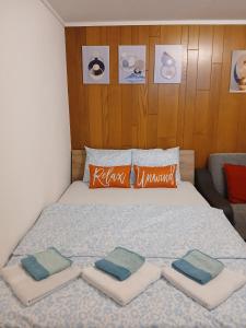 a bed with three pillows on it in a room at Zimmer mit Bad in Bühler