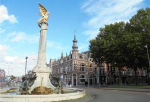 a fountain with a statue in front of a building at Little Duke Hotel in Den Bosch