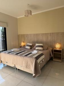 a bedroom with a large bed with two lamps at Exclusive Dúplex Iguazú in Puerto Iguazú +33 photos