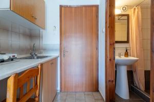 a kitchen with a sink and a wooden door at Studios Vaso in Neos Marmaras
