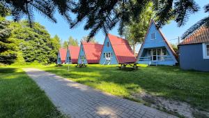 a row of houses with red roofs and a pathway at Nowa Siesta Camp Łeba in Nowęcin