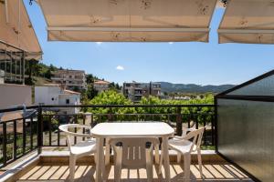 a white table and chairs on a balcony at Studios Vaso in Neos Marmaras