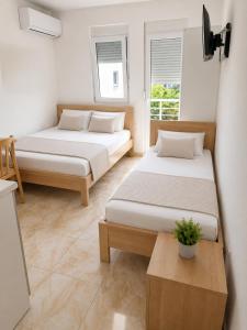 two beds in a room with two windows at Apartments Leyla in Ulcinj
