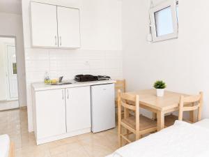 a white kitchen with a table and a sink at Apartments Leyla in Ulcinj